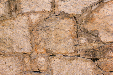 Natural old beige stone wall textured background. Close up. Copy space.