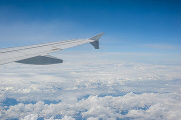 Obraz premium View from airborne airplane window at cloudy sky at high altitude.