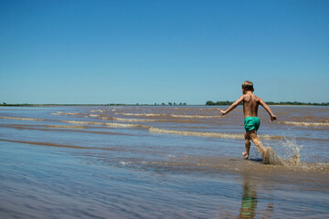 niño corriendo en la playa
