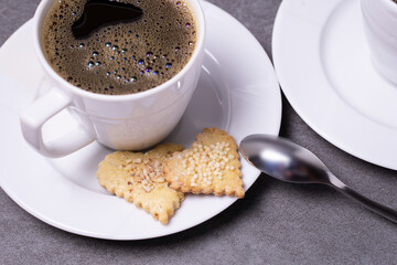Heart-shaped cookies on a grey plate with coffee. Background for Valentine's Day.	