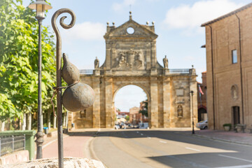 Fototapeta na wymiar a calabash on a walking stick (symbol of the way to Santiago) in front of the arch of San Benito in Sahagun, province of Leon, Castile and Leon, Spain