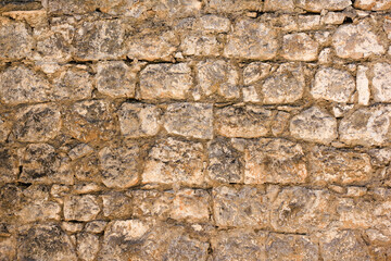 Natural old beige stone wall textured background. Close up. Copy space.