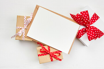 Valentines day greeting card mockup and gift boxes on white wooden background
