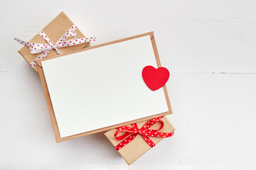 Valentines day greeting card mockup and gift boxes on white wooden background