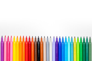 Set of markers placed in line on a white background. Focus on the foreground.