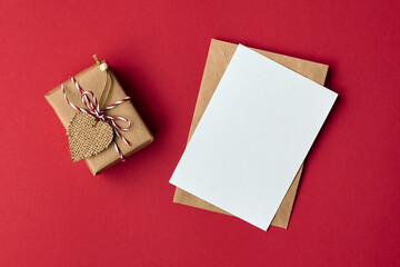 Valentines day card mockup with envelope and gift box with heart on red paper background