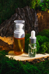 Skincare routine pipette bottles. Retinol, Hyaluronan, Antioxidant treatment Serum on green forest background