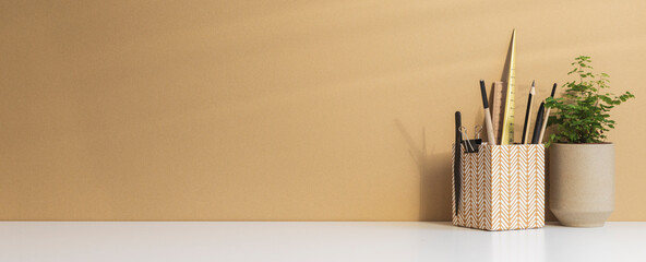 Office desk with space for poster, blank picture frame or text, desk objects, office supplies and bright beige background.	