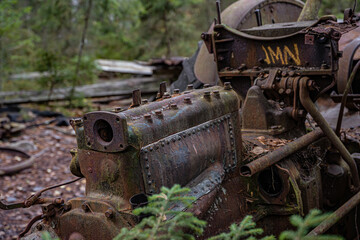 Old tractor in wild nature on the car cemetery of kyrkö Mosse in Sweden