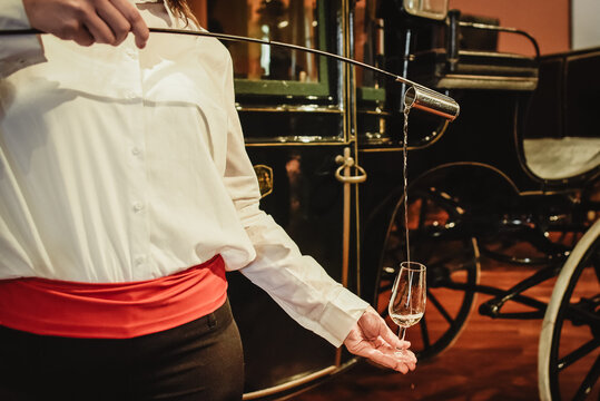 person serving a glass of manzanilla de Jerez, person holding a glass of wine