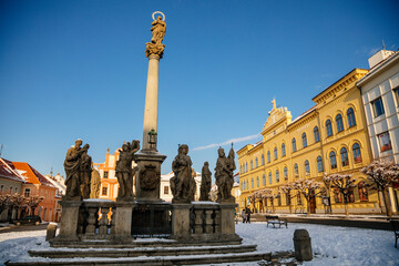 Fototapeta na wymiar Marian Column, Municipal Library and baroque and renaissance historical buildings at Alsovo Square in winter sunny day, royal medieval town Pisek, Southern Bohemia, Czech Republic