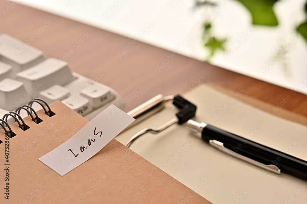 Poster a sticky note labeled iaas is taped to the edge of a notebook on the desk.that's an acronym for infr
