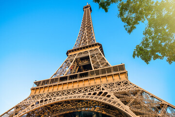 Fototapeta na wymiar Detail bottom view of Eiffel Tower on the blue sky background in sunset light