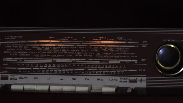 Close up of an retro radio with the marker running through the different stations and frequencies. Tuning Analog Radio.