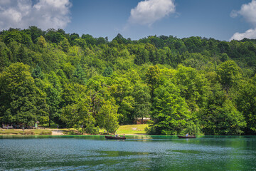 Tourists paddling in two paddleboats on emerald green lake in Plitvice Lakes National Park UNESCO World Heritage in Croatia