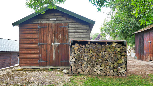 Wood shelter and cabin in the countryside with stacked firewood
