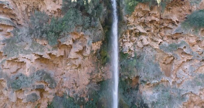 Mujer de mediana edad frente a altisima cascada de agua vista a&eacute;rea