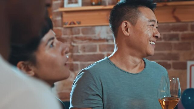 Lets get party. Multi-race happy company young attractive friends gathering in cafeteria and dancing into music while celebrating party holidays and drinking wine together. Friendly atmosphere concept