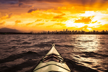 Kayaking in the ocean with modern city and mountains in background. Stormy Sunrise Colorful Sky Art Render. Taken in Jericho, Vancouver, British Columbia, Canada. Concept: Adventure, Lifestyle, Sport