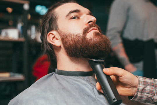 Photo of man making beard at barbershop.