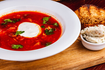 Traditional Ukrainian Russian borscht or beetroot red soup with sour cream in white plate