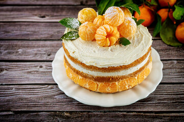 Obraz na płótnie Canvas Delicious mandarin or orange sponge cake decorated with fresh tangerine.