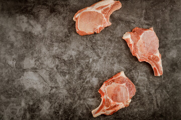 Sliced raw pork chops rib on gray background.