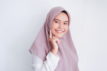 Young Asian Islam woman wearing headscarf with clean fresh white skin touching face with fingers...