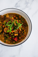 plant-based food, potatoes and garden vegetable roast with vegan broth and fresh tarragon