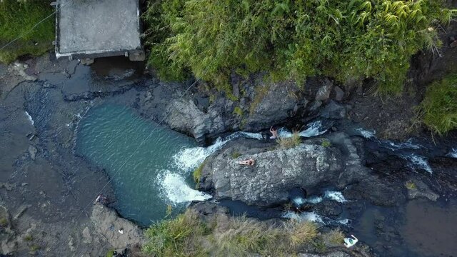Woman Sitting On The Rocky Cliff Of Bokong Falls In Sagada. - aerial drone