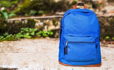 Blue school bag with school supplies on background