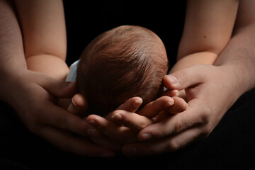 Baby head hold by parents hands 