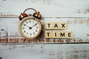 Tax Time  Word alphabet letters with alarm clock on wooden background