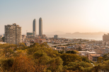 Xiamen city skyline with modern buildings, old town and sea at dusk