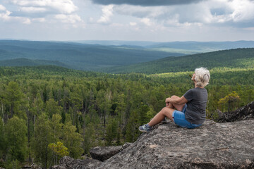 A free middle-aged woman enjoying wonderful view of the mountain valley.Healthy lifestyle and...