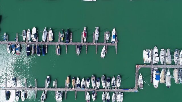 Aerial top view of boats and yachts in marina from above.Yacht parking A marina lot Yacht and sailboat is moored at the quay, Aerial view by drone camera in Phuket island