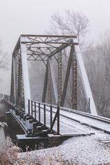 Snowy railroad bridge on a foggy winter day