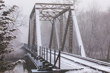 Snow covered railroad bridge on a foggy winter day