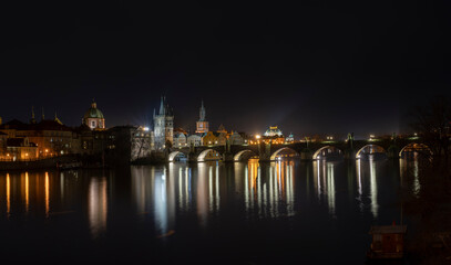 .panoramic view of Charles Bridge and illuminated street lights and the surrounding old architecture in the center of Prague in the Czech Republic at night