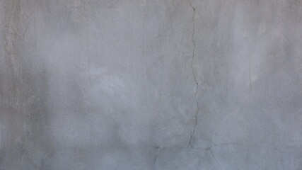 A cracked gray cement wall. Nasty grunge old abstract cement wall texture full framerate to design background. Selective focus