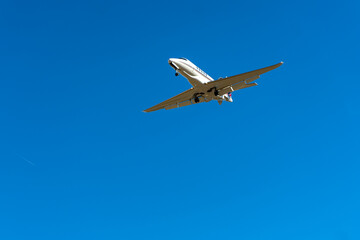 Fototapeta na wymiar Private jet plane flies in the blue sky.
