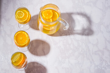 Lemonade with lemons and grapefruit in glass on white background. Cold summer refreshing drink or beverage