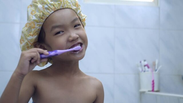 Slow motion scene of A 4-5 year old Asian girl brushing her teeth