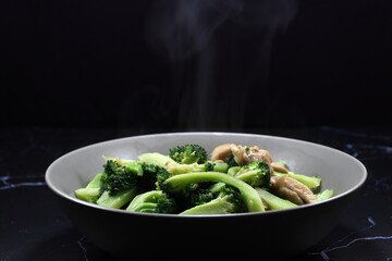 Classic fried fresh broccoli with chicken meat serving on the plate. Famous side dish menu in Chinese restaurant. 