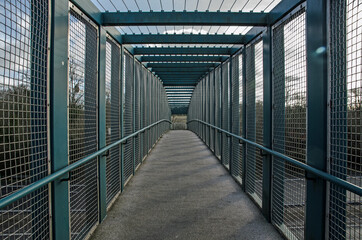 Caged footbridge over motorway, view from inside