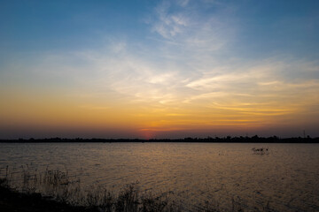 Obraz premium The sky at sunset, twilight colors beautifully with river or lake. Natural background