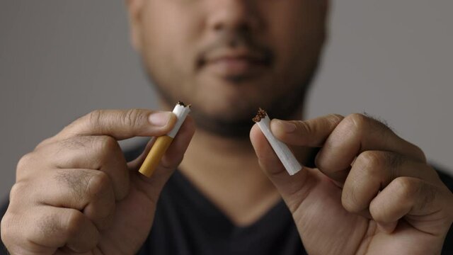 World No Tobacco Day. The young man quit smoking for his good health. He broke a cigarette in two.