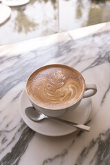 Cup of coffee on a marble table. Break time. Vertical. 