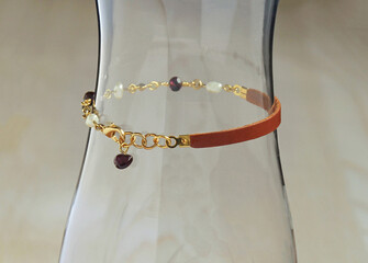 Brown leather strap bracelet with pearl and burgundy crystal beads.