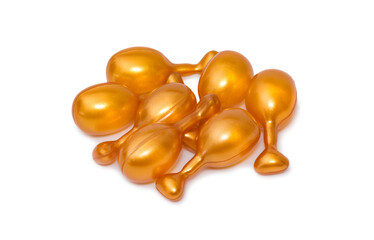 Gold capsules for face isolated on white background. Face serum
